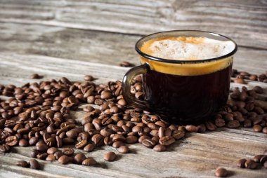  Güzel kokulu siyah kahve kahve çekirdekleri ve ahşap bir masa bir arka plan üzerinde fotoğrafı