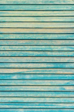 Zaman ve hava tarafından maviye boyanmış ve kısmen solmuş tahtaların dikey fotoğrafı.