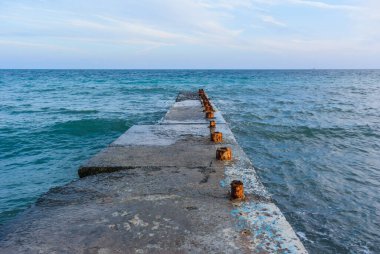 Denizdeki eski beton iskelenin fotoğrafı.