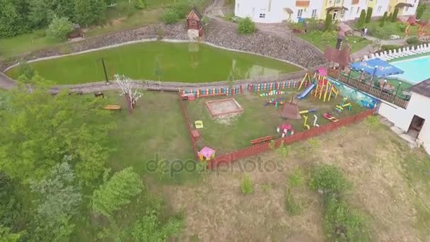 Un embalse artificial con un molino y el parque infantil en un complejo turístico — Vídeo de stock