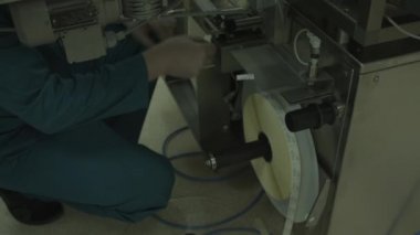 Kur donatım. İşçi ilaç fabrikası ekipmanları ayarlar. Dükkanı. Yakın çekim. Renk düzeltme.