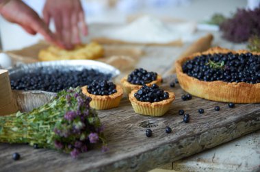 Üç yaban mersinli kek ve gri bir tahta üzerinde pişmiş kek