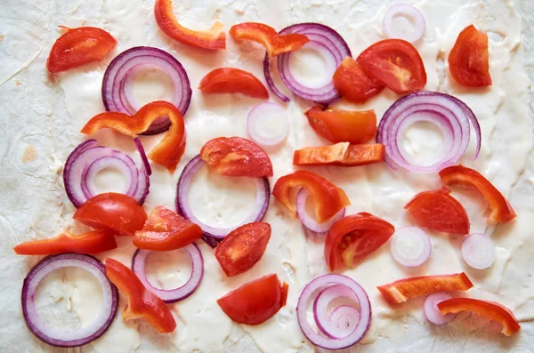Muchos trozos de verduras cortadas - cebolla morada, pimiento rojo y tomates. Compuesto caóticamente — Foto de Stock