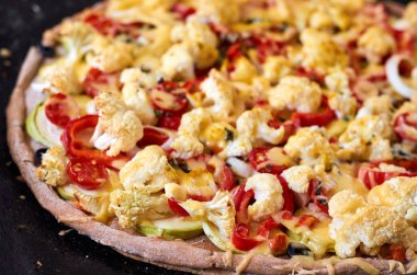 Kesme sebze - domates, biber, soğan, taze sıcak ev yapımı sebzeli pizza peyniri yakın çekim karanlık bir arka plan üzerinde