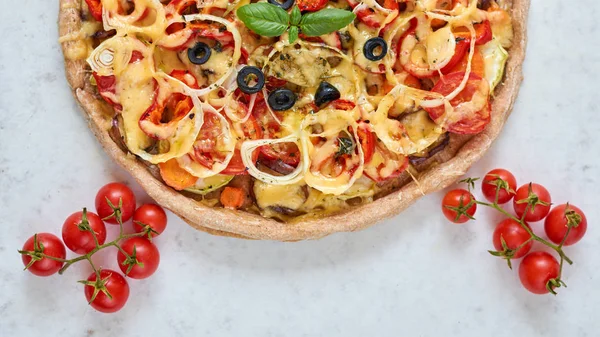 Pizza caliente recién horneada sobre fondo blanco. Pizza vegetariana con verduras y albahaca. Decorado con tomates cherry — Foto de Stock