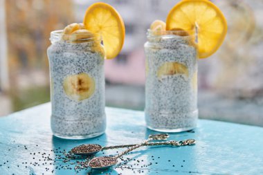 Mavi ahşap masa üzerinde iki vintage kaşık çiğ chia tohum. Chia sağlıklı güler yüzlü puding üzerinde gri arka plan bulanık. Detoks superfoods Kahvaltı