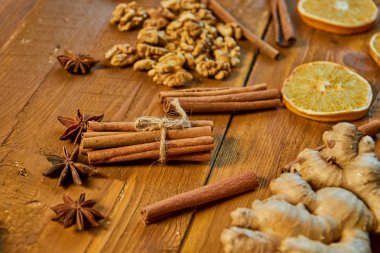 Tarçın ve anason yıldız ahşap kahverengi zemin üzerinde sopa. Mulled şarap için malzemeler: kurutulmuş meyve, portakal, zencefil, tarçın, anason ve fındık. Görünümü kapatın