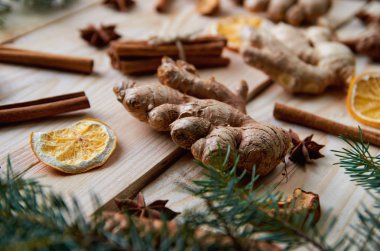 Zencefil ile geleneksel ahşap arka plan üzerinde parça malzemeler için Noel ekmek veya mulled şarap kurutulmuş portakal, elma, tarçın, anason yıldız baharatlar. Noel ağacı dalı ile dekore edilmiş