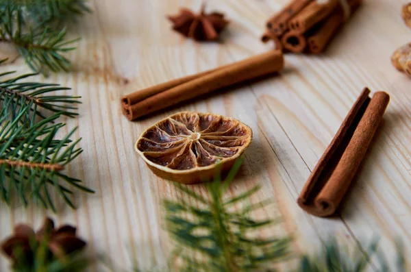 Narenciye ile tarçın, anason star Noel ağacı dalları ile dekore edilmiş ahşap arka plan üzerinde kurumuş. Geleneksel baharat mulled şarap, Noel ekmek için. Yeni yıl kompozisyon. Görünümü kapatın