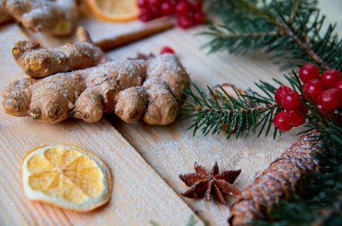 Toz zencefil kurutulmuş portakal, anason, çiğ kırmızı kartopu meyveleri ile ahşap arka plan üzerine kapatın. Bulanık Noel ağacı dalı ve çam koni ile dekore edilmiştir. Yeni yıl kompozisyon. Natürmort. Düz yatıyordu