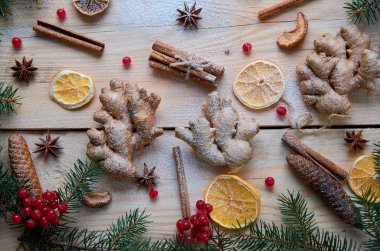 Zencefil ile geleneksel baharat turuncu, anason, tarçın, kartopu ahşap arka plan üzerinde üç adet pudra. Noel ağacı dalları, çam kozalakları ile dekore edilmiştir. Yeni yıl kompozisyon. Üstten Görünüm