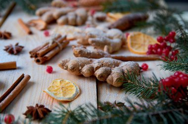 Toz zencefil, tarçın, portakal, anason çiğ kırmızı kartopu çilek ahşap arka plan üzerinde. Bulanık Noel ağaç dalları ve çam kozalakları ile dekore edilmiştir. Yeni yıl kompozisyon. Natürmort. Düz yatıyordu