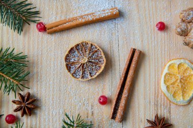 Toz baharat için mulled şarap veya Noel ekmek turuncu, anason, tarçın, zencefil ve taze kırmızı kartopu ahşap arka plan üzerinde meyveleri. Noel ağacı dalı ile dekore edilmiştir. Düz yatıyordu, en iyi görünümü