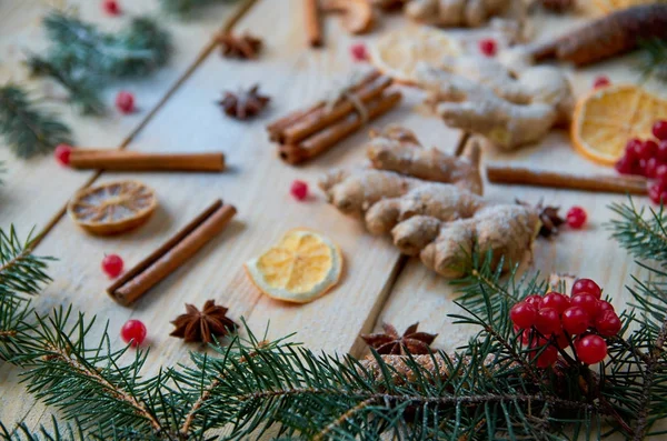 Ön plan üzerinde çiğ kırmızı kartopu çilek ile Noel ağacı dalları. Geleneksel toz baharat için mulled şarap ya da Noel ekmek üzerinde arka plan bulanık. Düz yatıyordu. Tatil ruh. Yan görünüm