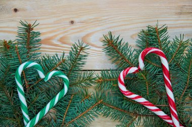 Yeşil ve kırmızı kalpler şeker koniler ücretsiz kopya alanı ile Noel ağacı dalları üzerinde. Yeni yıl ya da Sevgililer günü tatlılar süsleri çam dalları üzerinde ahşap arka plan ile. Üstten Görünüm