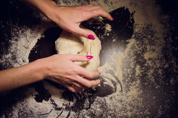 Egy lány készül tésztát pizza a fekete háttér — Stock Fotó