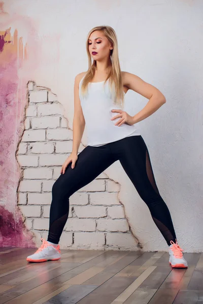 De trainer van de geschiktheid van jonge blonde meisje vrouw toont oefening pose — Stockfoto