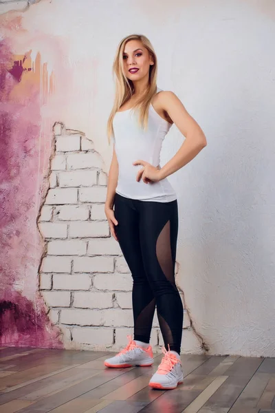 De trainer van de geschiktheid van jonge blonde meisje vrouw toont oefening pose — Stockfoto
