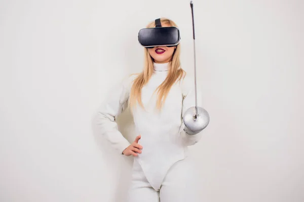 Woman wearing fencing suit practicing with sword against grey vignette vr — Stock Photo, Image