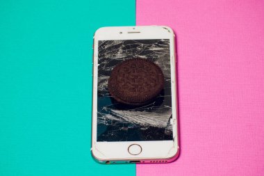 Yığılmış kırık ekran çikolatalı kurabiye ile modern hareket eden smartphone süt kavramı, modern bir mobil işletim sistemi hizmet.