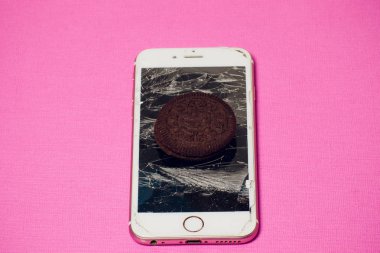 Yığılmış kırık ekran çikolatalı kurabiye ile modern hareket eden smartphone süt kavramı, modern bir mobil işletim sistemi hizmet.