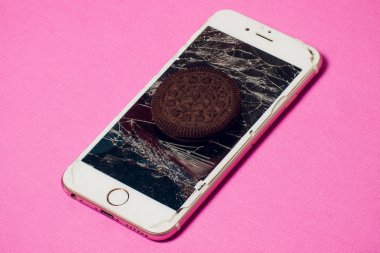 Yığılmış kırık ekran çikolatalı kurabiye ile modern hareket eden smartphone süt kavramı, modern bir mobil işletim sistemi hizmet.
