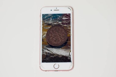 Yığılmış kırık ekran çikolatalı kurabiye ile modern hareket eden smartphone süt kavramı, modern bir mobil işletim sistemi hizmet.
