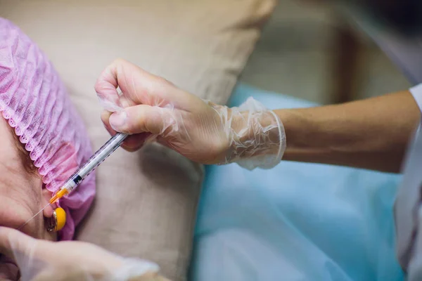 Il cosmetologo medico fa la procedura di iniezione facciale ringiovanente per stringere e levigare le rughe sulla pelle del viso di una bella, giovane donna in un salone di bellezza.. — Foto Stock