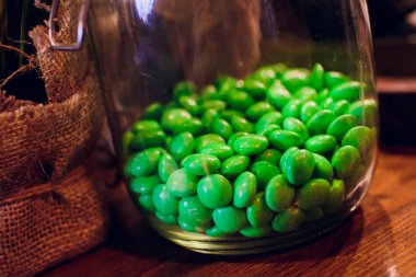 Ahşap arka plan üzerinde bir kasede yeşil sır içinde fındık