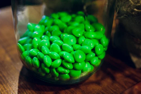 Noten in groen glazuur in een kom op een houten achtergrond — Stockfoto