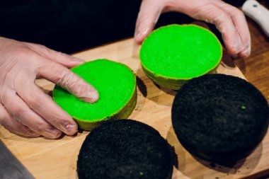 Baker ekmek buns burger için pişirme görünümünü kapatın. Ahşap masa üzerinde ekmek hamur hazırlama eller. Geleneksel ev yapımı ekmek hazırlanıyor. Otel hizmet anlayışı.