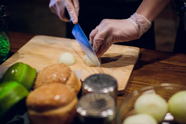 Manos de chef con cuchillo cortando la cebolla en la tabla de madera. Preparación para cocinar. Alimentación saludable y estilo de vida . — Foto de Stock