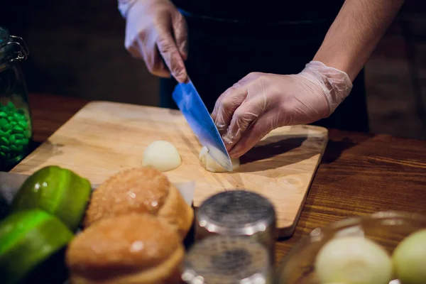 Manos de chef con cuchillo cortando la cebolla en la tabla de madera. Preparación para cocinar. Alimentación saludable y estilo de vida . — Foto de Stock