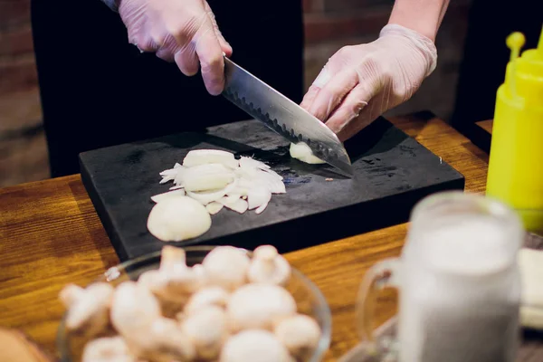 Manos de chef con cuchillo cortando la cebolla en la tabla de madera. Preparación para cocinar. Alimentación saludable y estilo de vida . — Foto de Stock