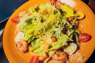 Ahşap plakalar üzerinde beyaz tabakta taze Sezar salatası