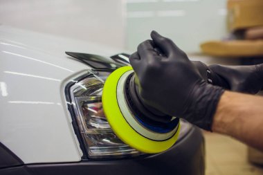 otomatik mekanik cilalama ve araba Far araba - oto tamircisi yörünge Parlatıcı ile adam detaylandırma parlatma. Seçici odak.