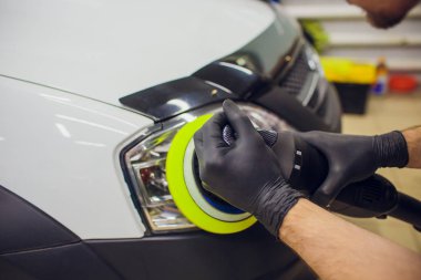 otomatik mekanik cilalama ve araba Far araba - oto tamircisi yörünge Parlatıcı ile adam detaylandırma parlatma. Seçici odak.