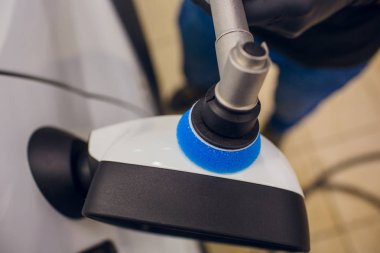 Araba - işçi oto tamircisi yörünge Parlatıcı ile ayrıntılı. Araba ayna Lehçe. Seçici odak. Eller yörünge Parlatıcı ile