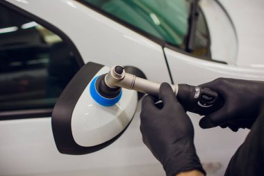 Araba - işçi oto tamircisi yörünge Parlatıcı ile ayrıntılı. Araba ayna Lehçe. Seçici odak. Eller yörünge Parlatıcı ile