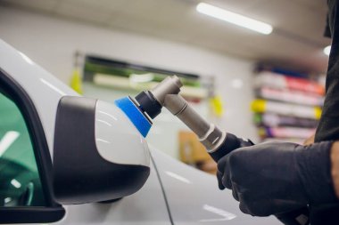 Araba - işçi oto tamircisi yörünge Parlatıcı ile ayrıntılı. Araba ayna Lehçe. Seçici odak. Eller yörünge Parlatıcı ile