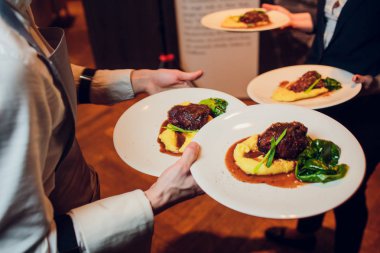 Garsonlar et yemeği bir düğün gıda ile tabak taşıma