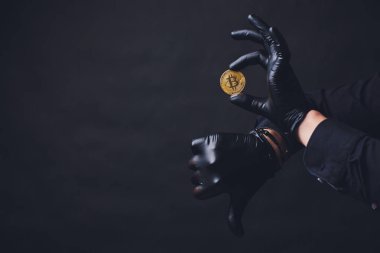 Bitcoins koluna yerleştirilen siyah eldiven elinde simge göster. Siyah arka plan üzerine izole