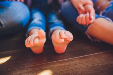 Küçük bebek ayaklar holding yetişkin ebeveyn eller