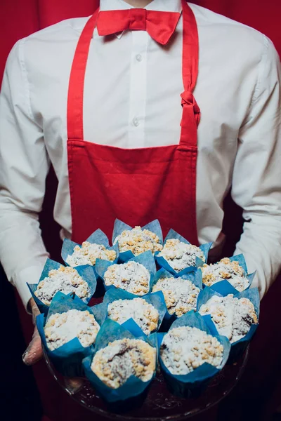 Baker mantiene una bandeja con el hombre pan fresco en panadero uniforme rojo y blanco sosteniendo una bandeja con la fabricación de pan — Foto de Stock