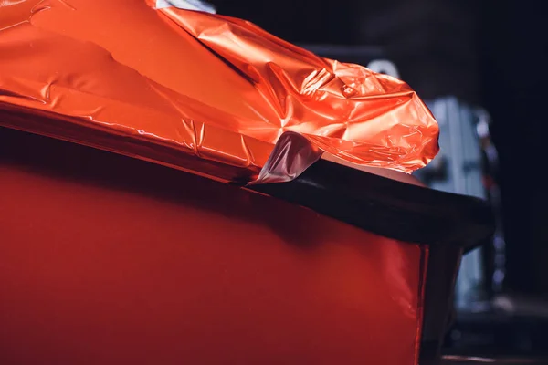 Auto wrapping specialist aanbrengen van vinyl folie of film op auto. beschermfolie met zaklamp te snijden. jacht, boot, schip, auto, stacaravan te verpakken. Oranje film — Stockfoto