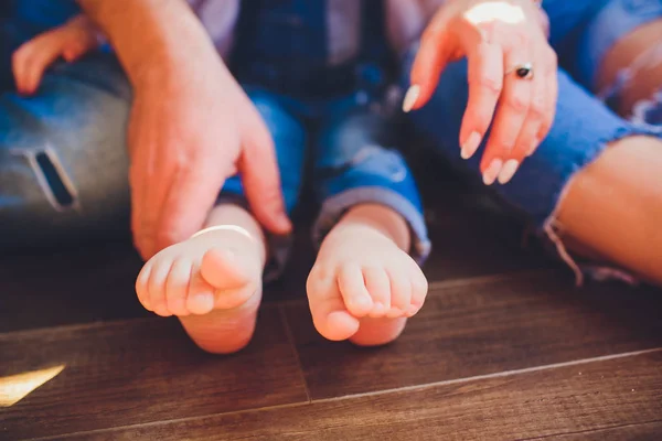 Adults parents hands holding little baby feet — Stock Photo, Image