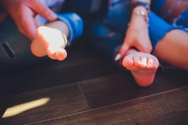 Adulti genitori mani che tengono piccoli piedi bambino — Foto Stock