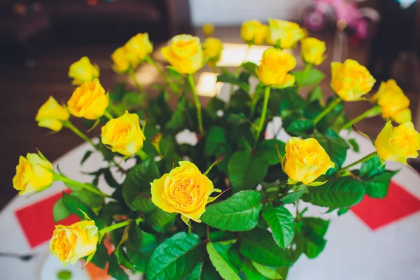 Жовті троянди у вазі на столі. Свята та концепція святкування — стокове фото