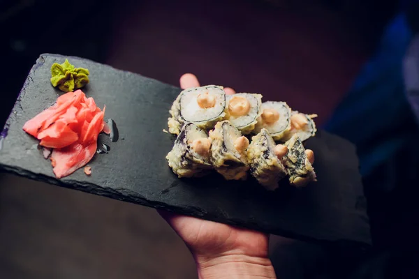 Waitress in sushi restaurant with sushi plate