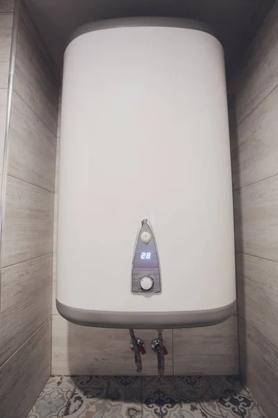 Omedelbar tankless elektrisk varmvattenberedare installerad på vit kakel vägg med ingång och utgång röret utlopp och elcb säkerhetsbrytare system. — Stockfoto